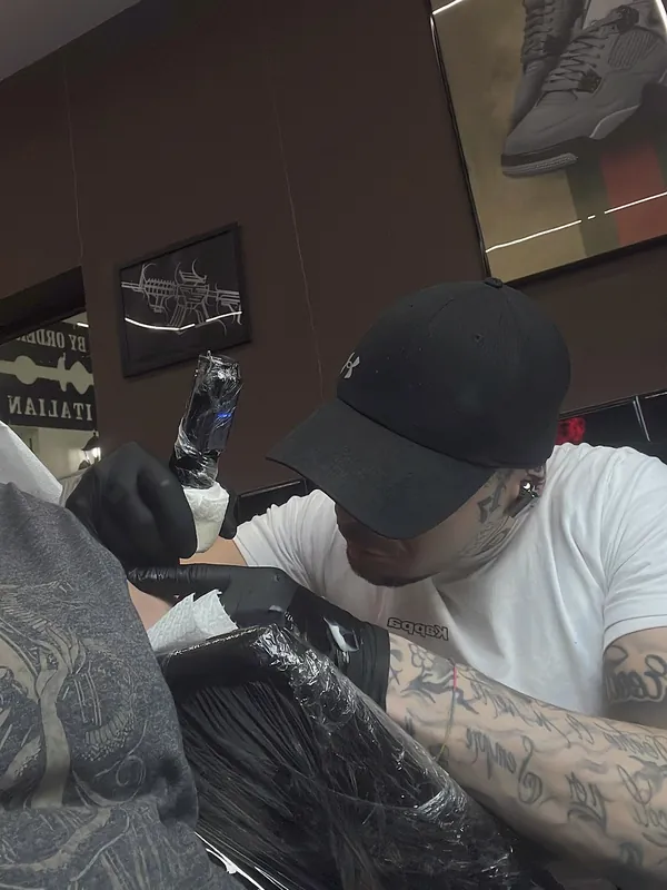 Tatuatore al lavoro su un braccio